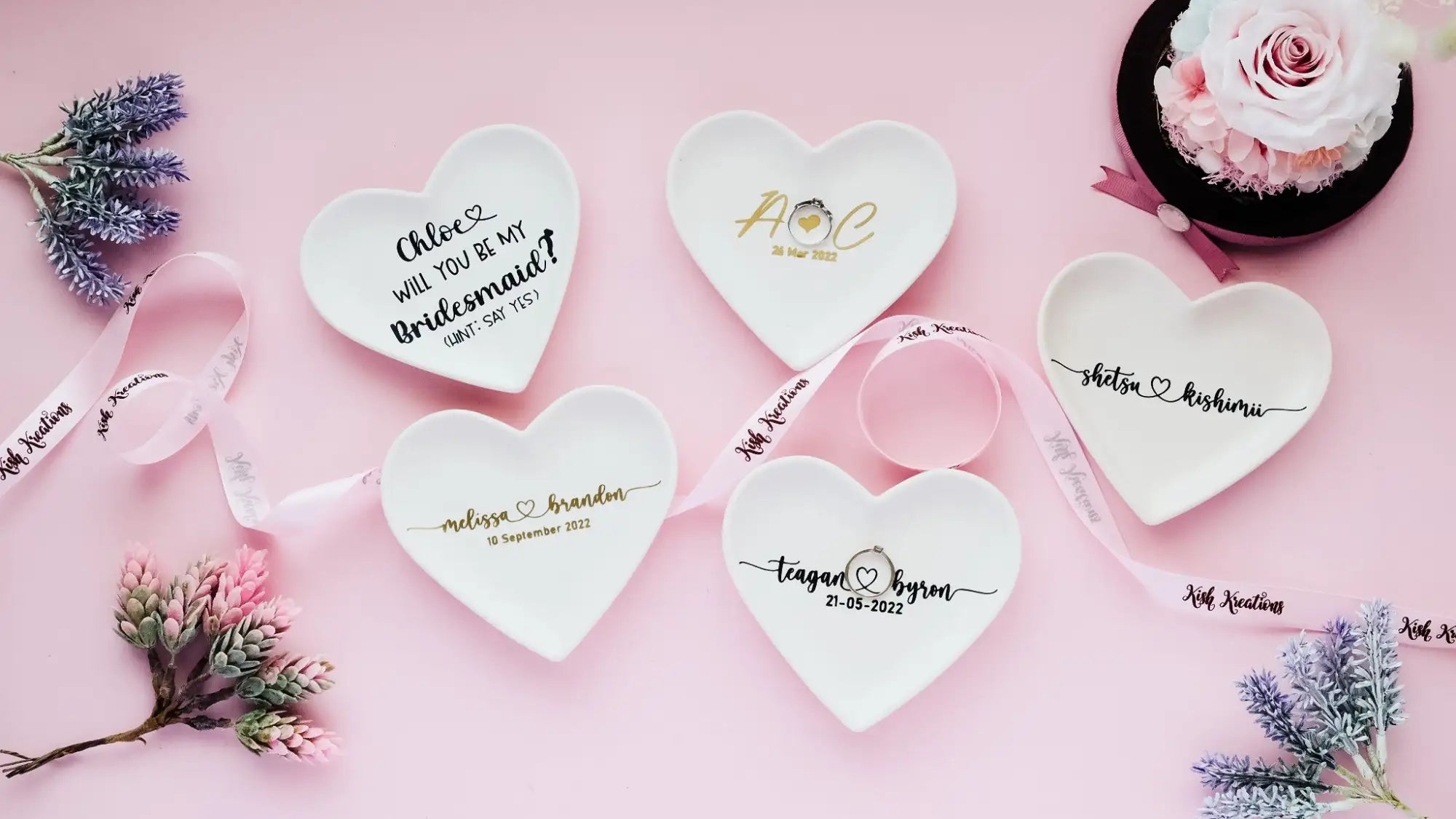 White ceramic heart-shaped trinket dishes with personalized gold script and initials.