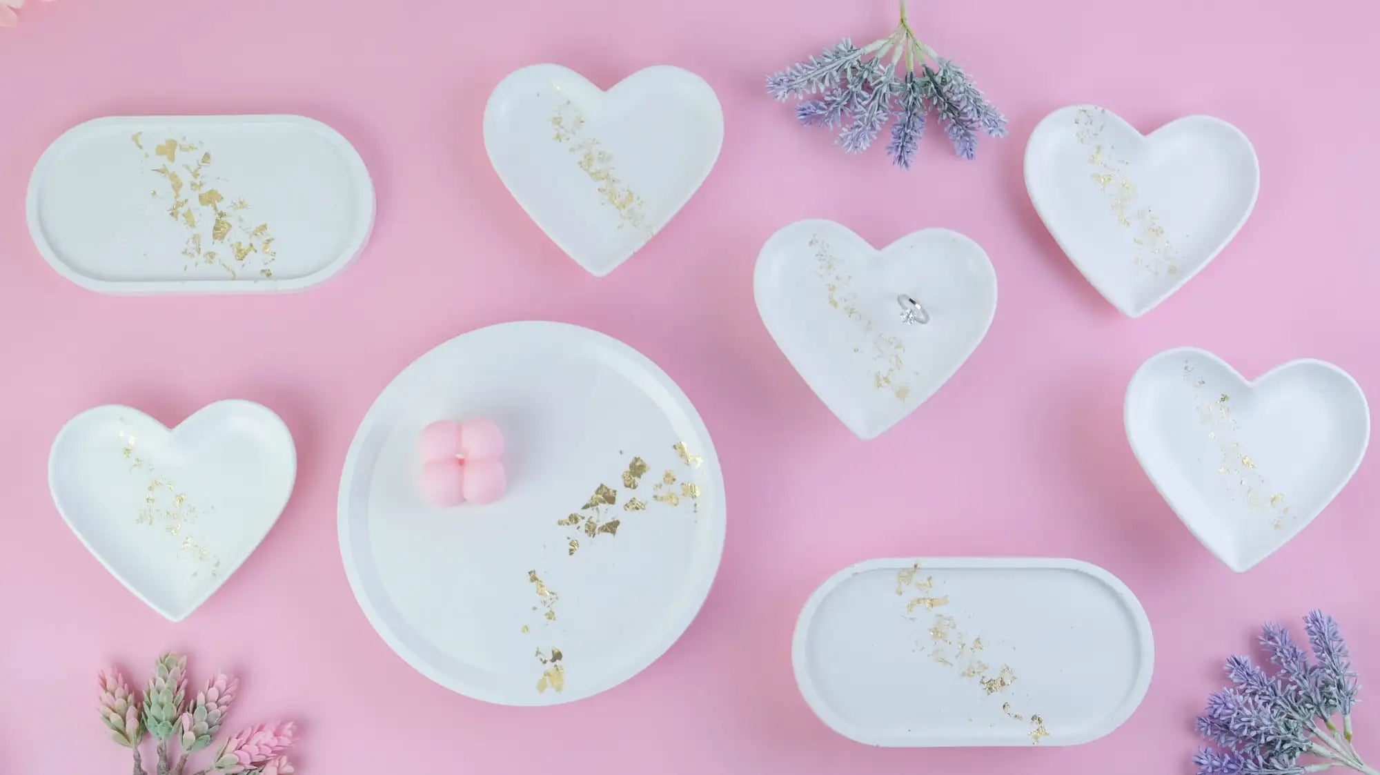 White ceramic trays with gold leaf accents, shaped in hearts and ovals.